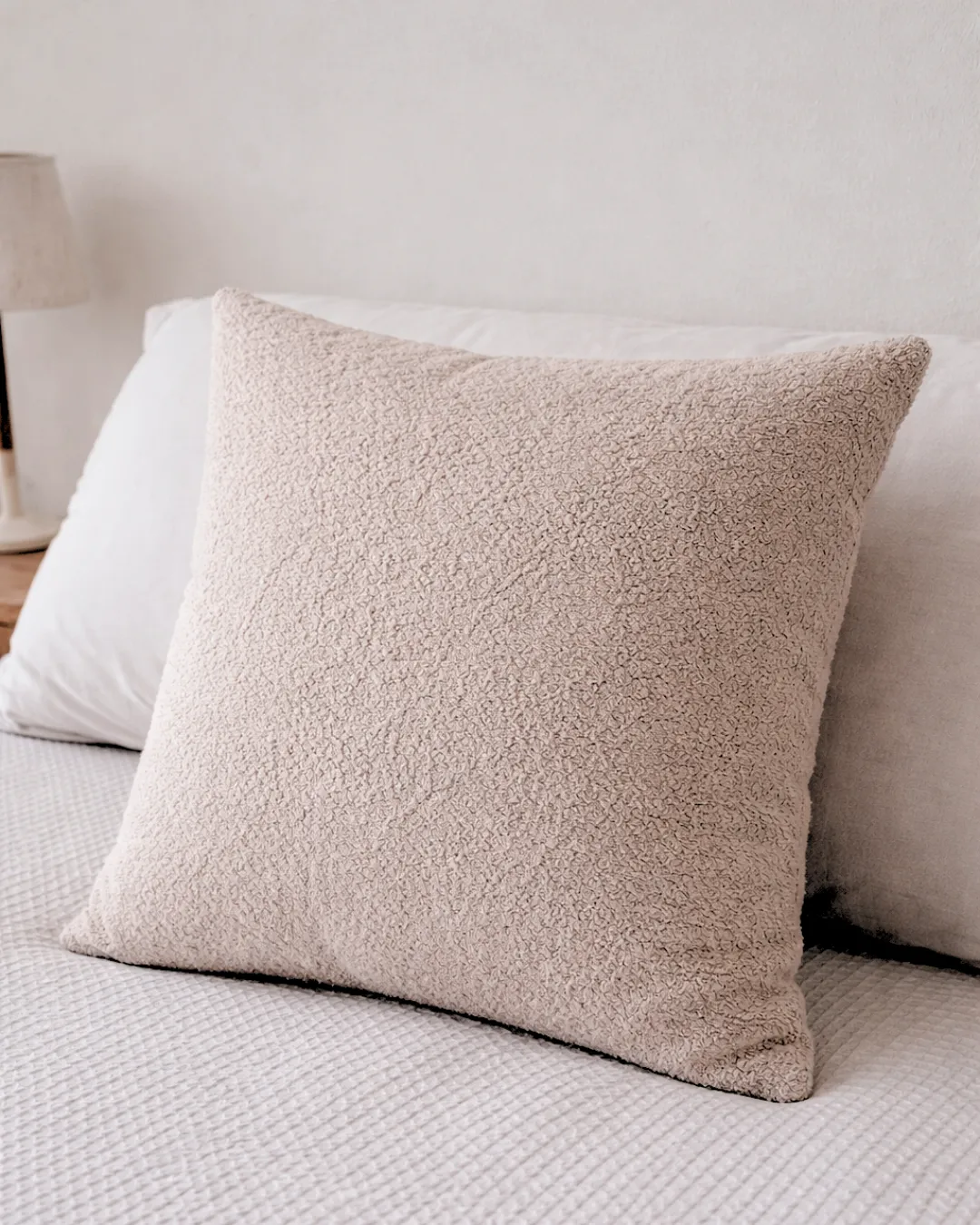 Almohadón de textura bouclé en tono visón.